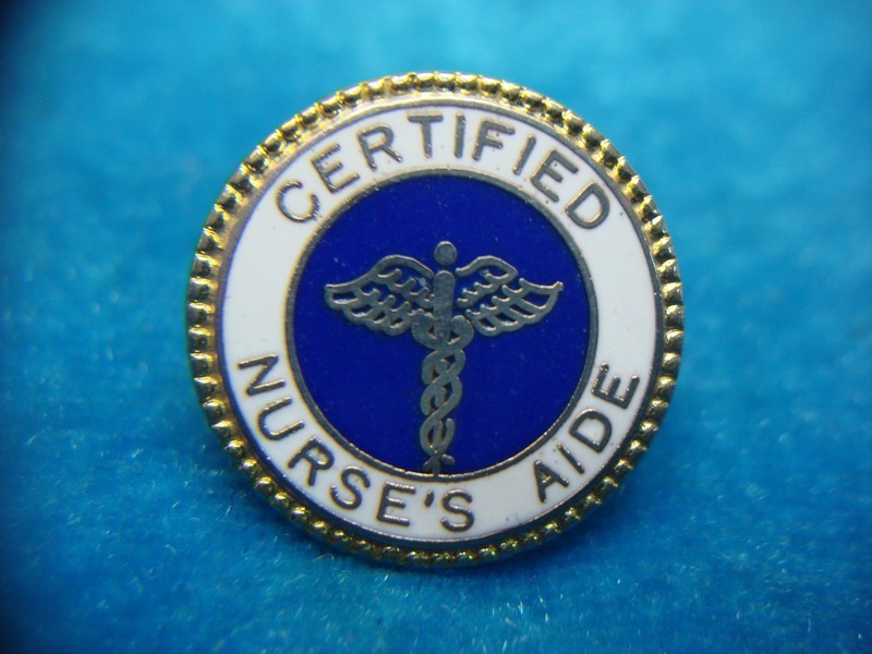 Vintage gold-tone nurse's aide pin with white and blue enamel