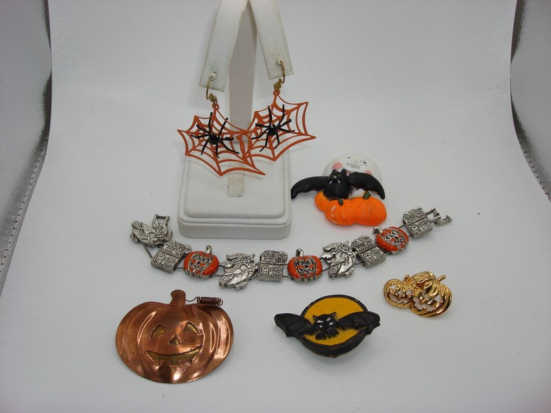 Vintage Halloween jewelry set with bracelet, pins, and earrings featuring witch, pumpkin, and bat motifs.
