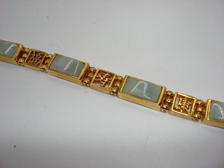 Gold-tone Chinese jadeite bracelet with intricate symbol design