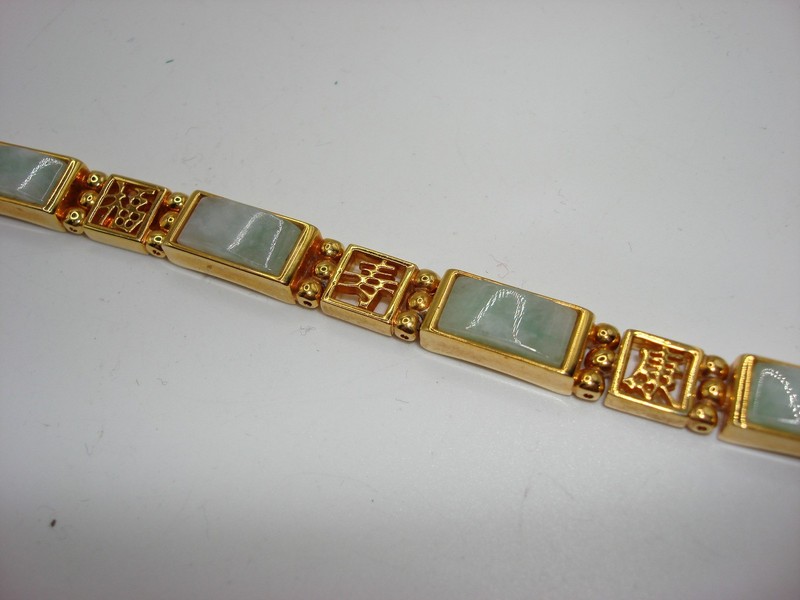 Gold-tone Chinese jadeite bracelet with intricate symbol design