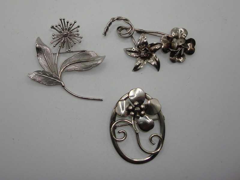 Vintage sterling silver floral pins, a set of three with hallmarks 'STERLING', 'JEWELART', and 'BEAU STERLING'