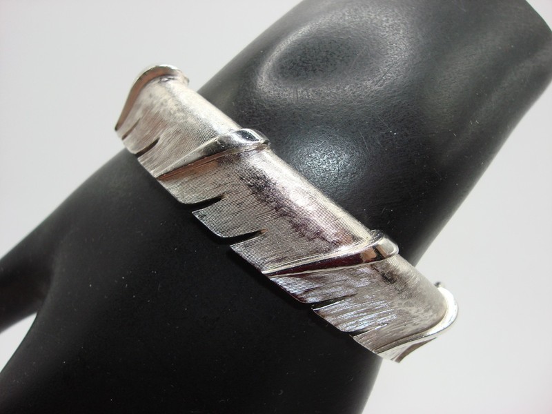 Vintage Trifari crown bangle bracelet with fluted and spliced design in silver tone.