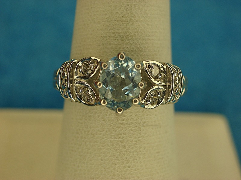 Sterling silver ring with a pale blue gemstone and simulated diamond accents, size 8