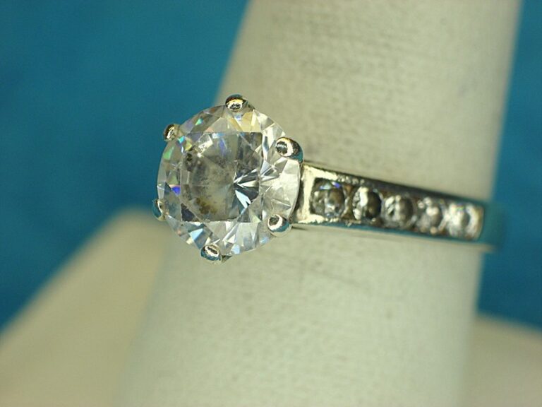 Sterling silver filigree ring with a large round simulated diamond and smaller accent stones, size 9