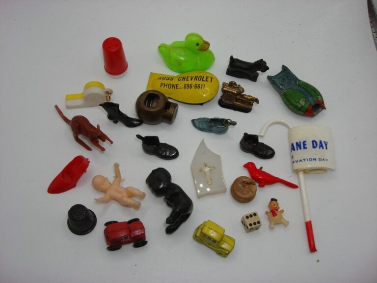 Collection of 24 vintage Cracker Jack prizes and collectibles, including miniature toys, figurines, and Americana finds.