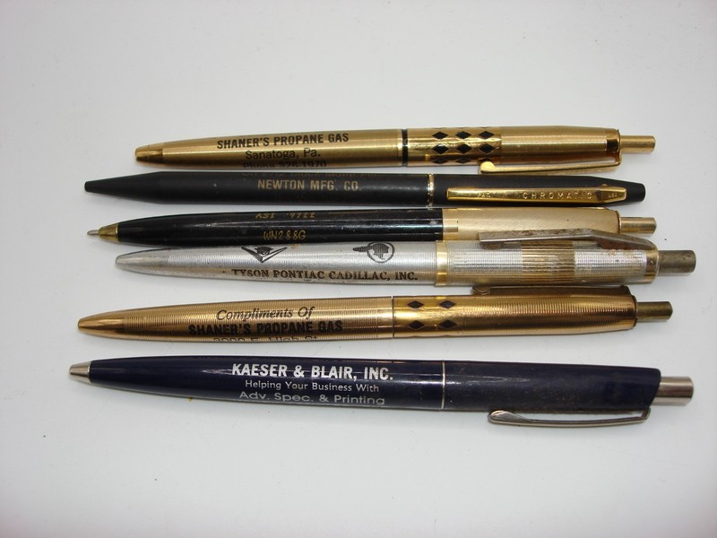 Set of six vintage advertising ballpoint pens from the 1970s and 1980s, featuring brands like Shaner's Propane, Tyson Pontiac, and Kaese & Blair.