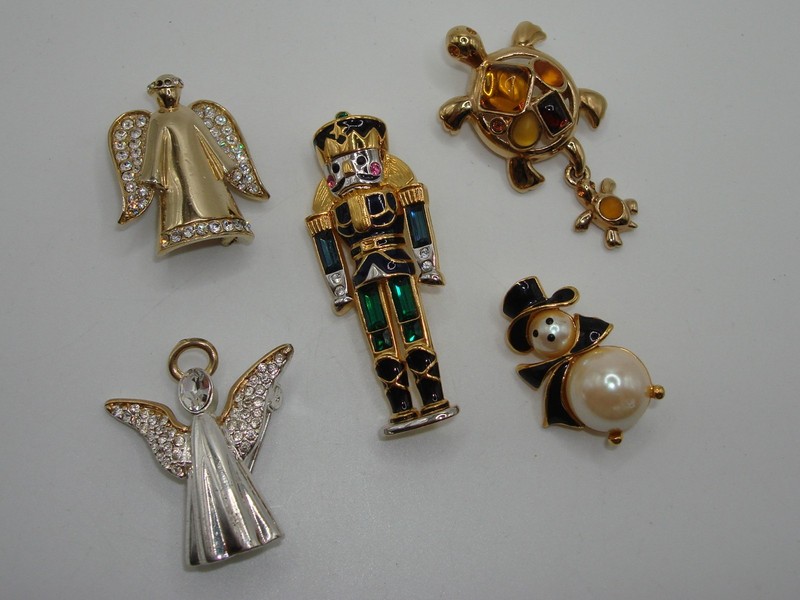 Collection of five vintage Monet pins featuring a soldier, angels, snowman, and more.