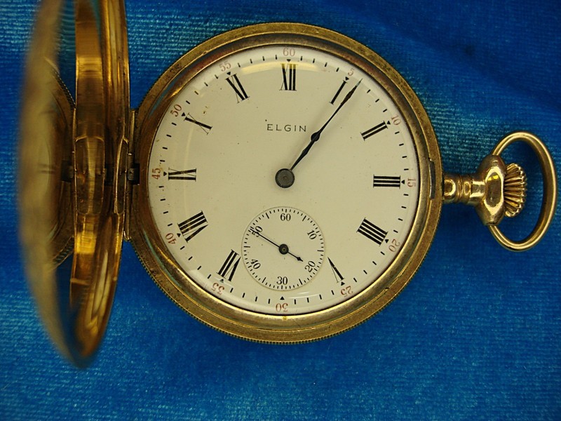 Antique Elgin Grade 290 pocket watch in a hunt case, featuring intricate designs and a small monogram.