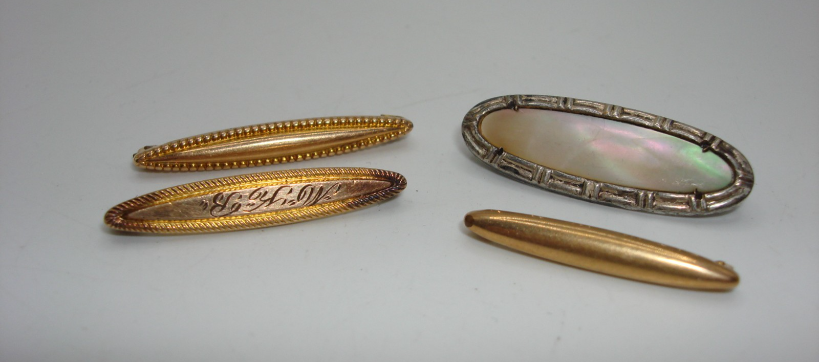 Set of four antique Victorian lingerie pins in silver, gold tone, and unique designs.