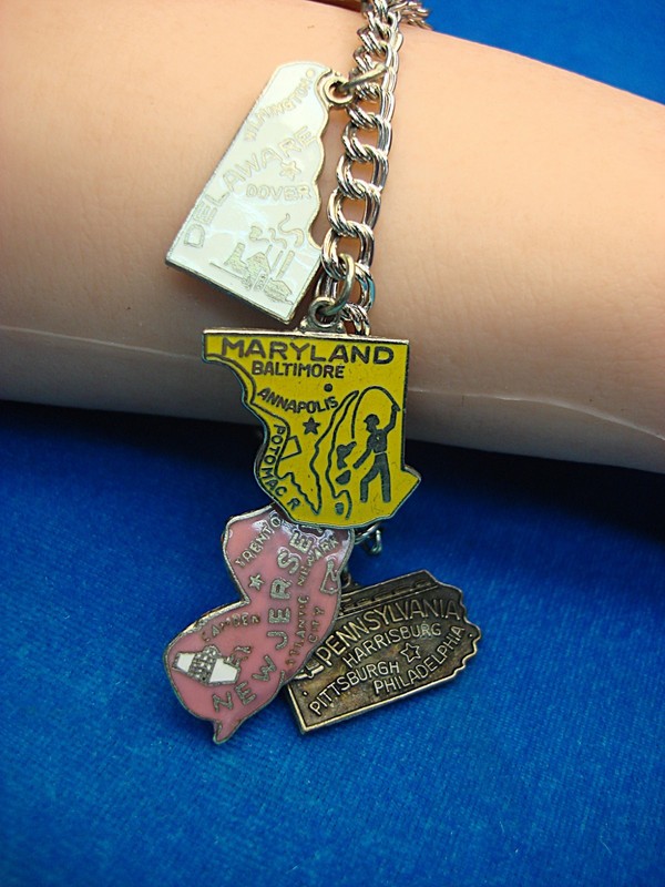 Silver-tone charm bracelet with six enameled charms representing US states and Washington D.C.
