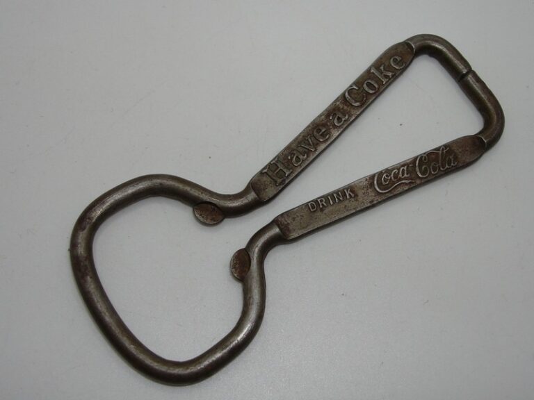 Vintage silver metal Coca-Cola bottle opener with 'Have a Coke' and 'Drink Coca-Cola' slogans.