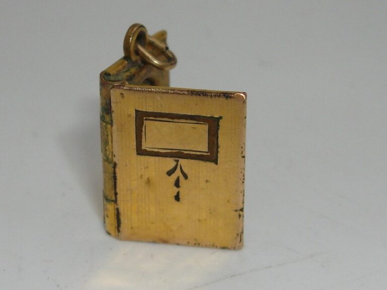 Antique Victorian gold-filled book locket charm with engraved cover and picture compartments.
