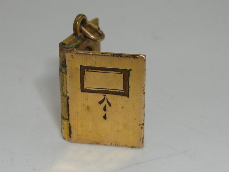 Antique Victorian gold-filled book locket charm with engraved cover and picture compartments.