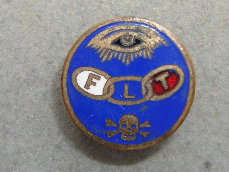Antique Odd Fellows enamel button pin, early 1900s, featuring a skull and crossbones emblem.