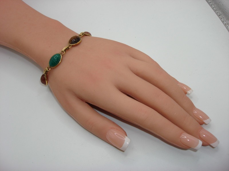 Vintage 1960s scarab bracelet made of 14K gold filled metal and featuring carved gemstone scarabs