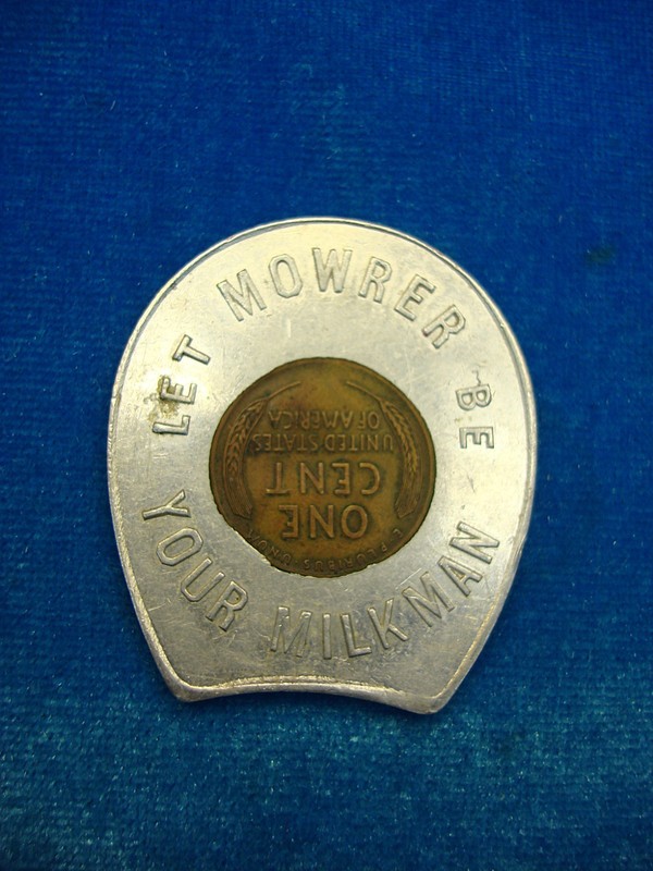 Vintage horseshoe token 'Let Mowrer Be Your Milkman' encased in a Lincoln cent