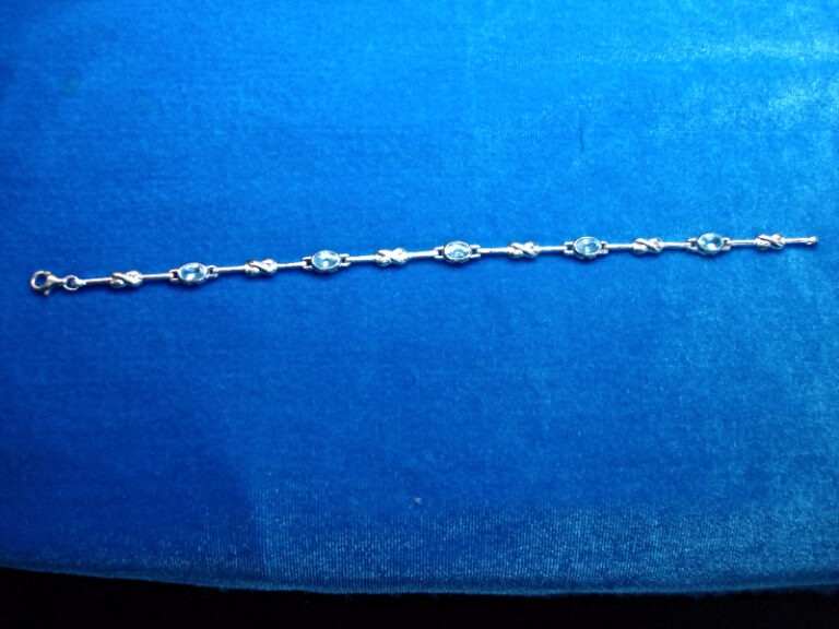 Sterling silver bracelet with X's and O's design and pale blue gemstones