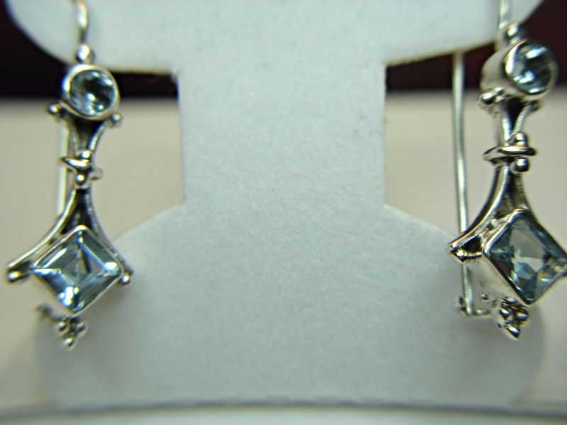 Sterling silver dangle earrings with blue topaz stones