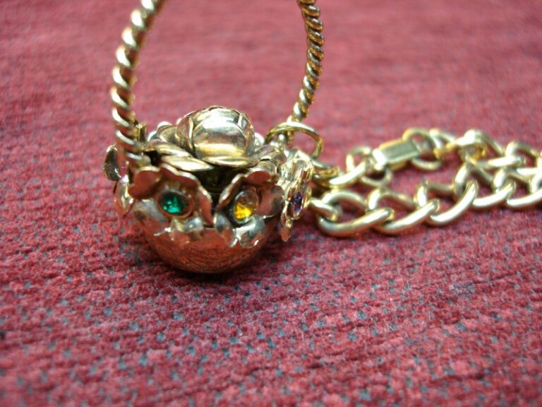 Vintage gold tone charm bracelet with a basket of flowers charm featuring multicolored stones