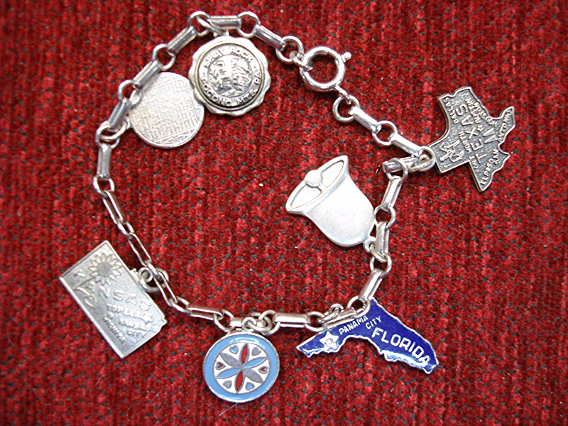 Vintage sterling silver charm bracelet with seven unique travel charms.