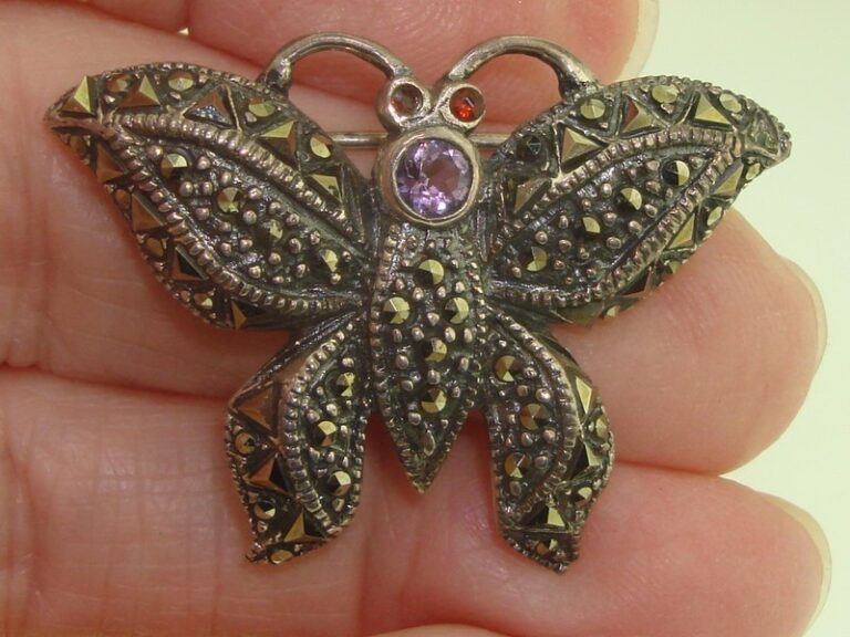 Vintage sterling silver butterfly pin with marcasite, amethyst, and garnet stones.