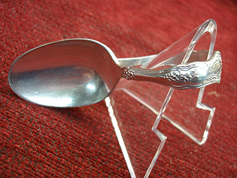 Antique 1847 Rogers Bros. silverplate baby spoon with a curved handle.