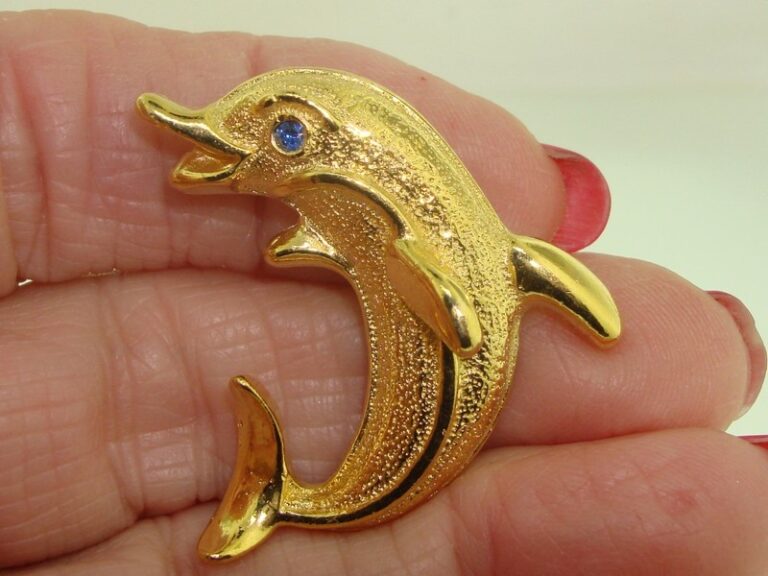 Vintage 1970s Gerry's gold-tone smiling dolphin pin with blue rhinestone eye