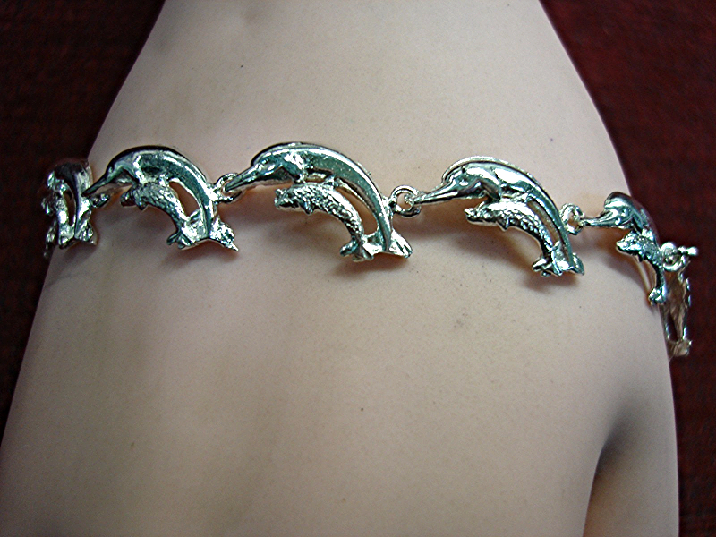 Sterling silver dolphin bracelet with 11 linked dolphins and calf detailing