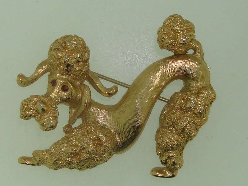 Vintage Monet gold-tone curly poodle pin with red rhinestone eyes