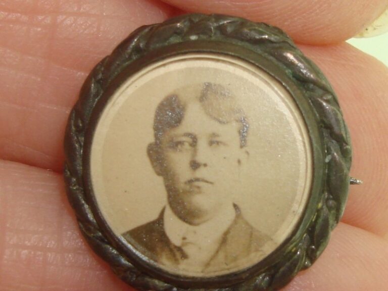 Antique Victorian mourning photo pin with hinged beveled glass and sepia portrait of a man in a suit