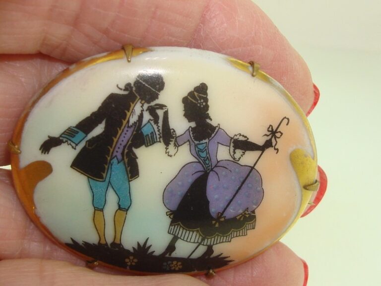 Antique hand-painted Limoges porcelain pin featuring a silhouette couple in period clothing with gold trim.