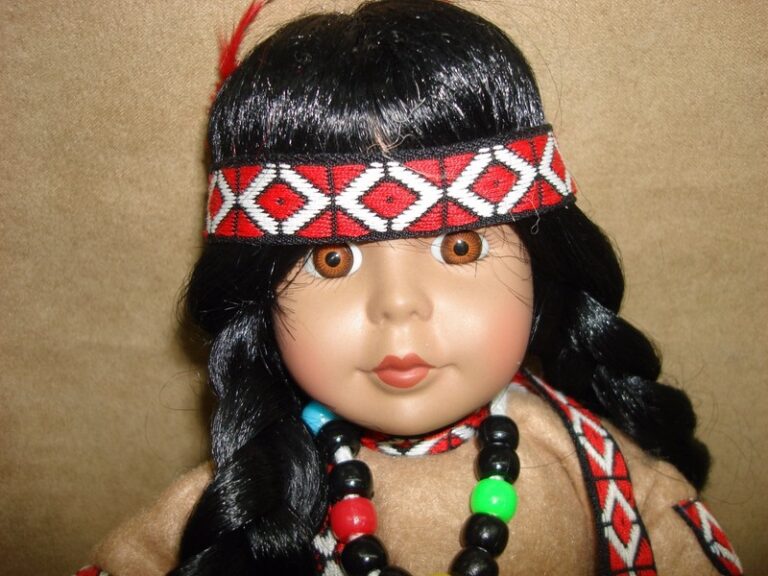 Vintage Paradise Galleries Native American porcelain doll, 1991, wearing a felt dress and accessories