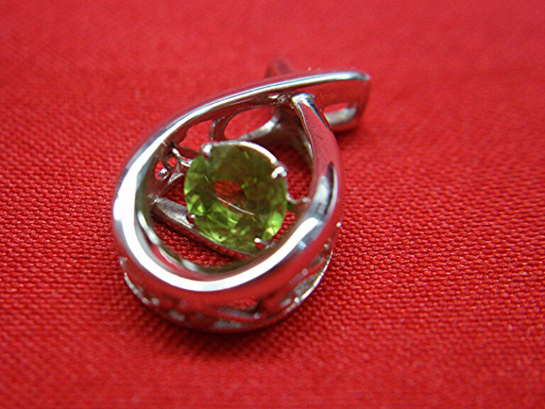Sterling silver peridot pendant with heart-inspired design.