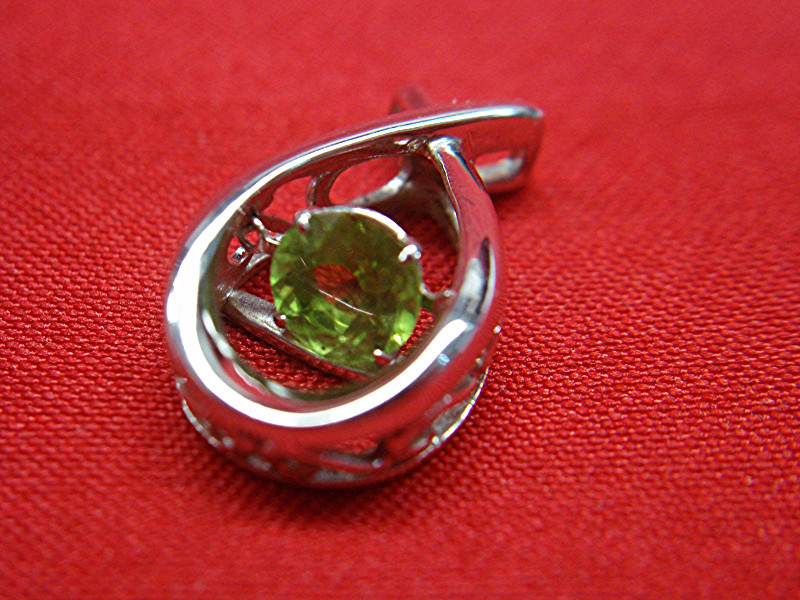 Sterling silver peridot pendant with heart-inspired design.