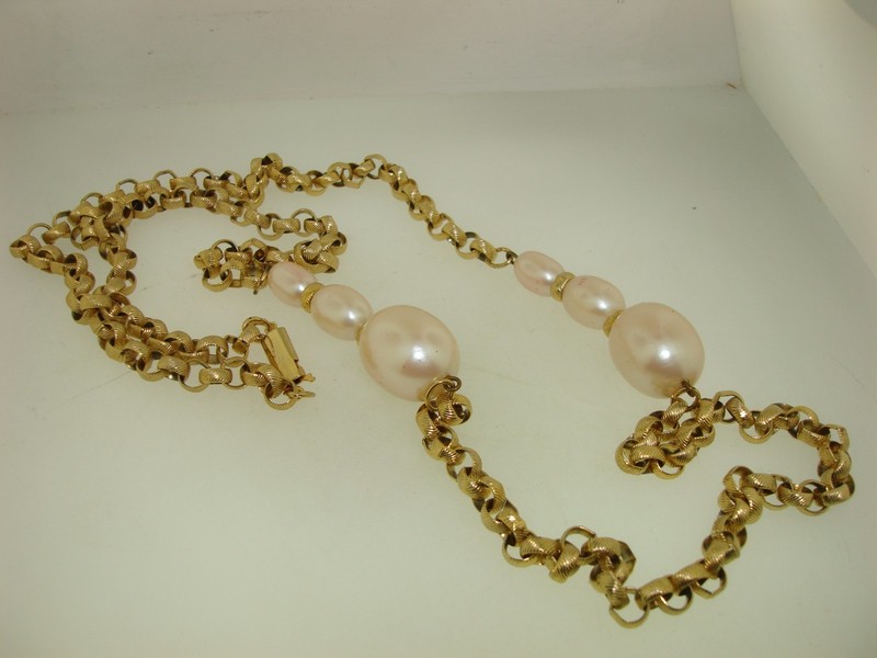 Vintage 1980s gold-tone faux pearl necklace with graduated pearls and intricate chain links.