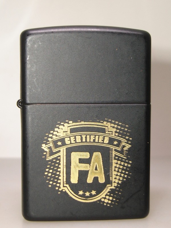 Rare 2012 Zippo black matte lighter with gold 'FA' etching and certified inscription.