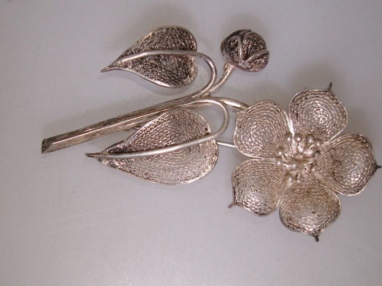 Vintage 1960s spun silver flower brooch pin with intricate floral design.