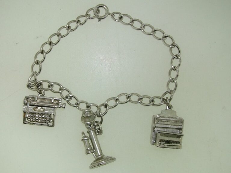 Vintage sterling silver charm bracelet with three working mechanical charms: a candlestick telephone, a typewriter, and an organ.