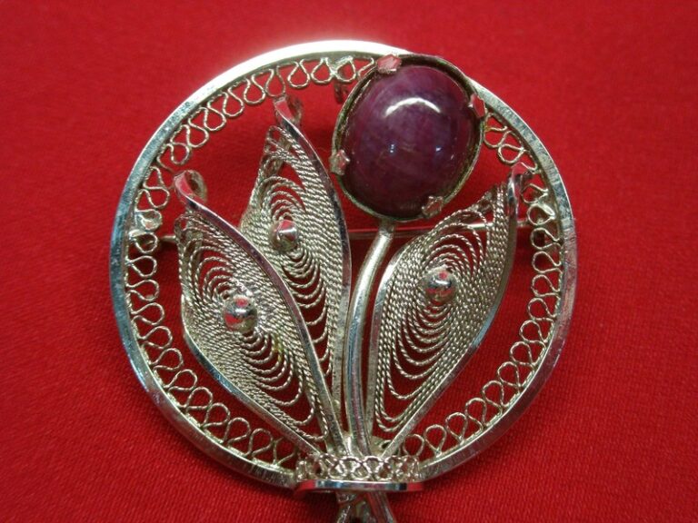 Vintage sterling silver circle pin with purple jade and ornate design.