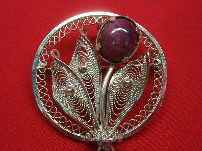 Vintage sterling silver circle pin with purple jade and ornate design.