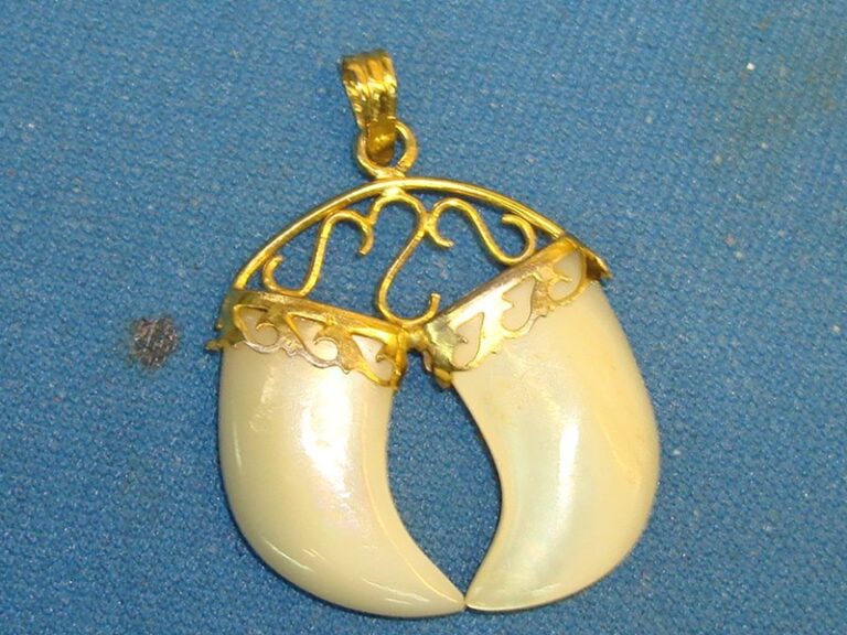 Vintage mother of pearl good luck pendant with carved tusks in gold tone