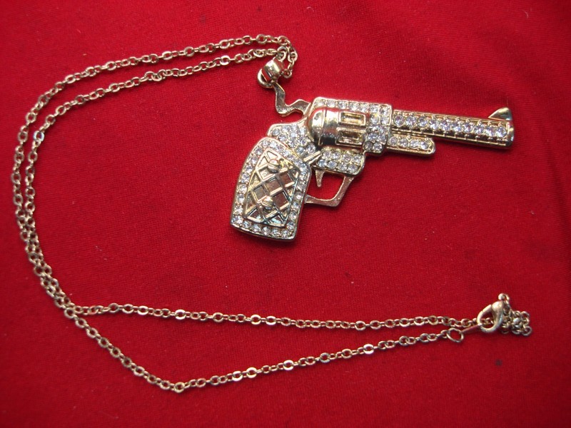 Gold-tone revolver pendant necklace with simulated diamonds